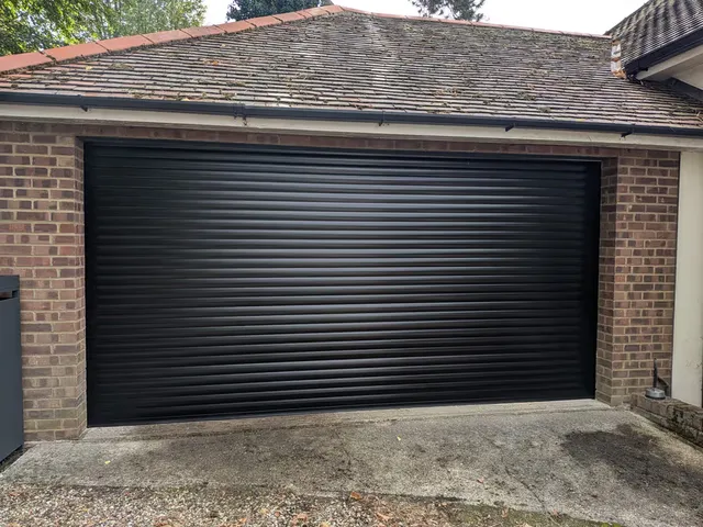 Black roller garage doors installed on a double garage in Basildon by Rollrite