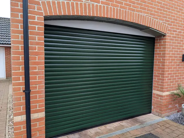 Moss green roller garage door on a brick home near Basildon